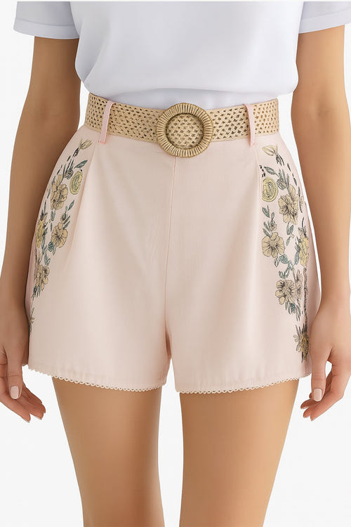 
Zoom sur le short taille haute rose pâle à motifs floraux, révélant sa texture légère idéale pour les journées d'été.



