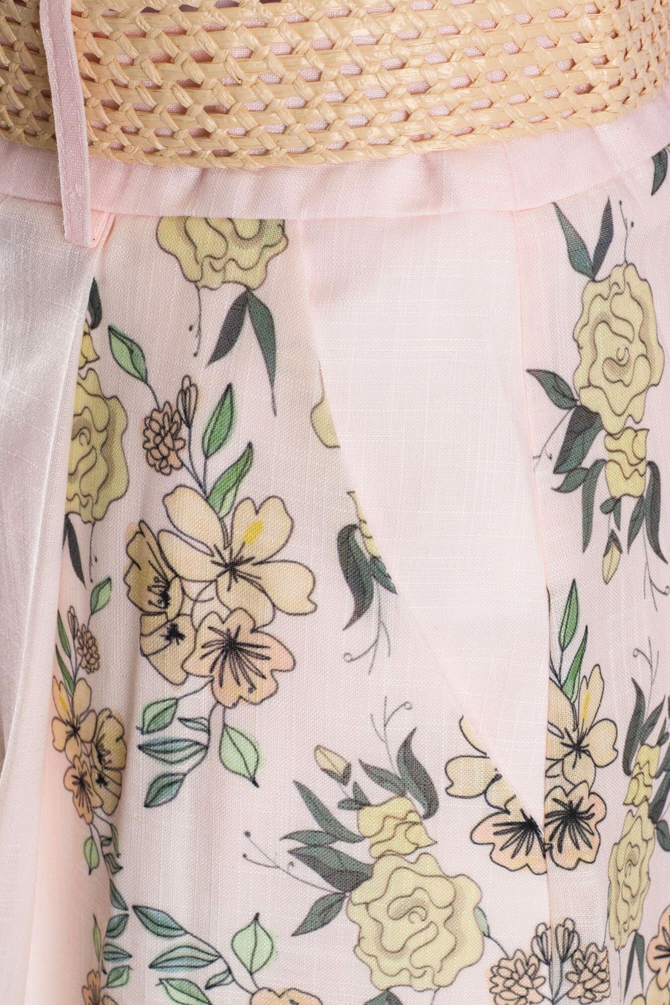 Detailansicht des hoch taillierten Shorts in blassem Rosé mit floralem Druck, ideal für sommerliche Outfits und elegante...