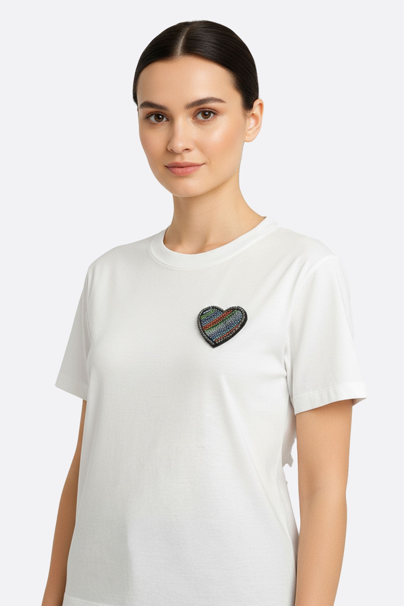 T-shirt bianca oversize con maniche corte e ricamo a cuore, perfetta per outfit eleganti e casual, ideale per ogni occasione.