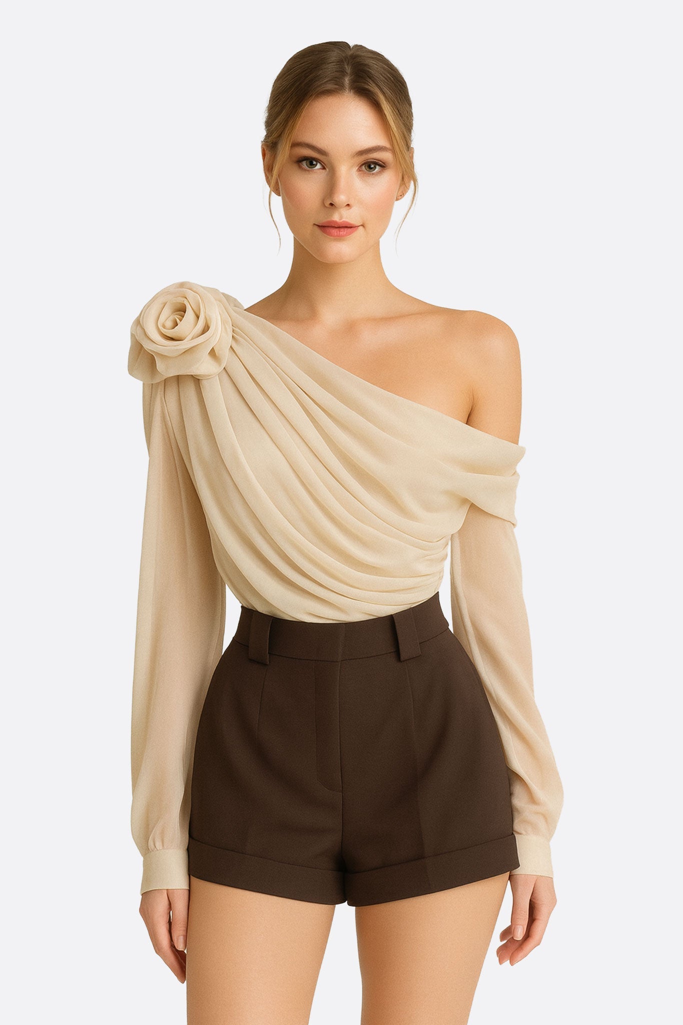 Top asymétrique en blanc écru, drapé avec une fleur sculptée, parfait pour une soirée élégante.