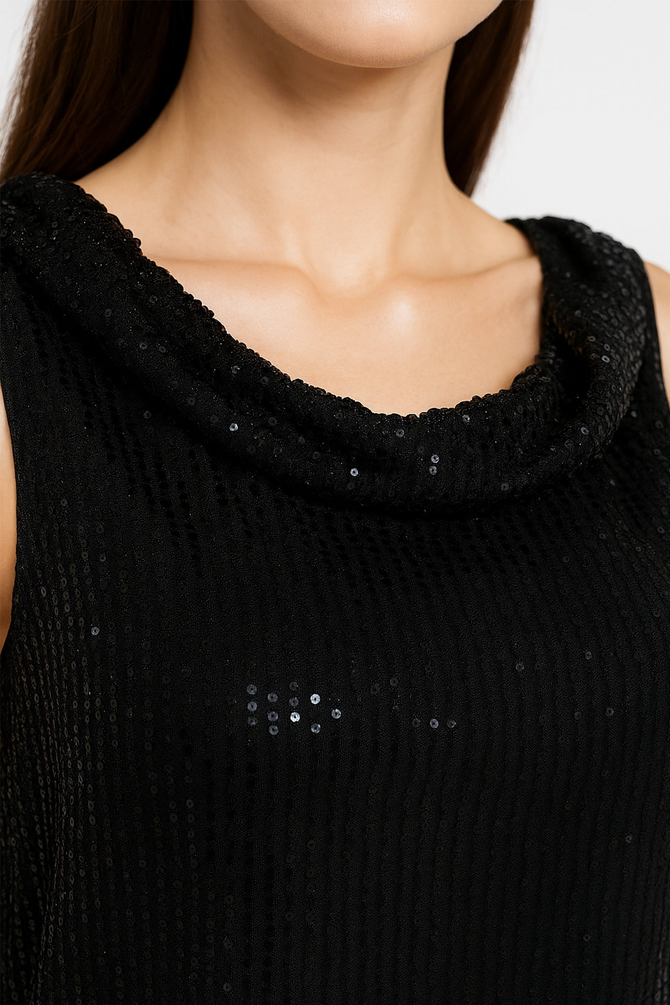 Détail du haut noir chic sans manches, rehaussé de sequins étincelants, parfait pour illuminer vos soirées élégantes.