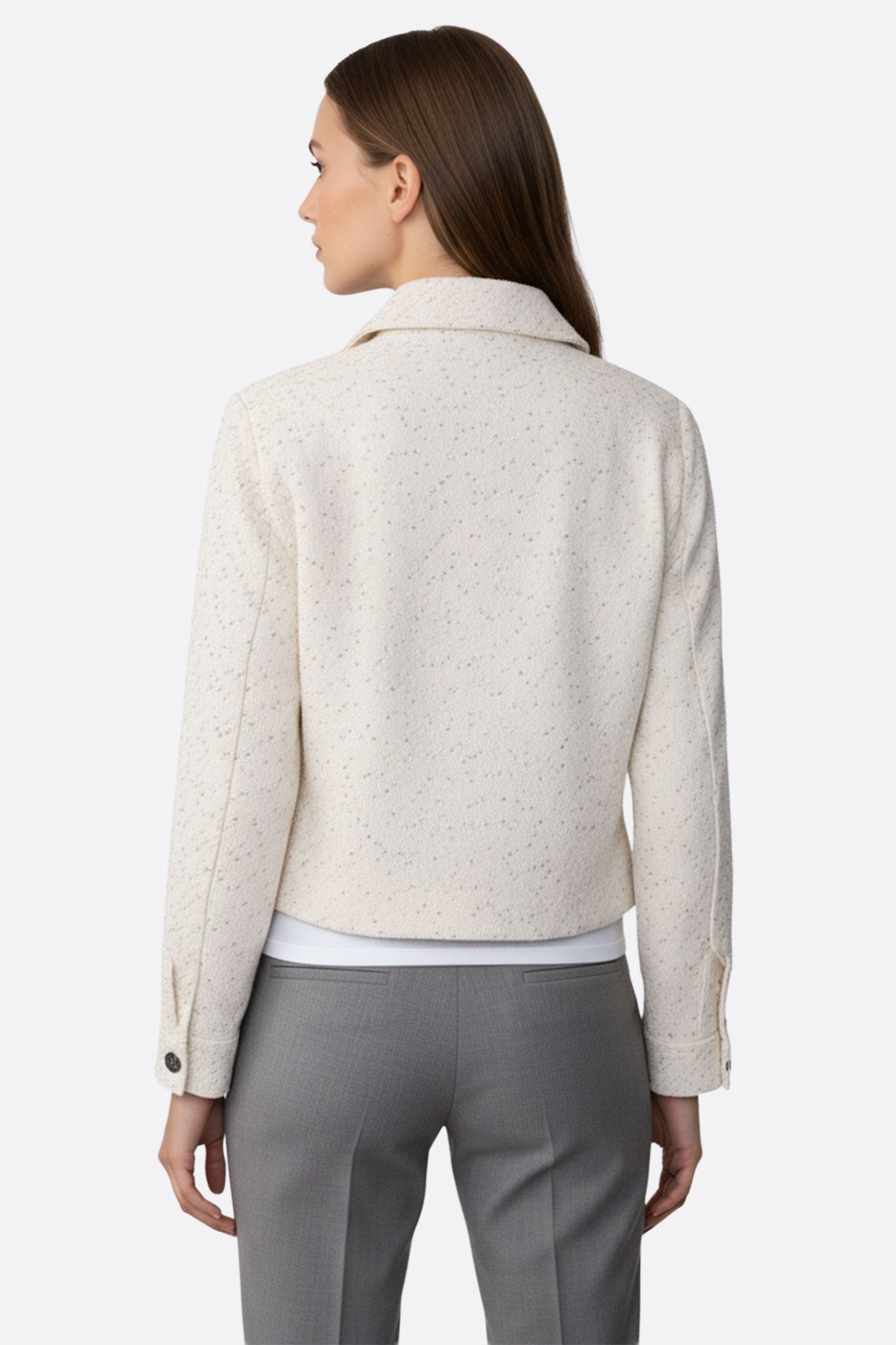 
Détails d'une veste courte en tweed blanc ornée de sequins, une pièce élégante pour sublimer une tenue de fête.



