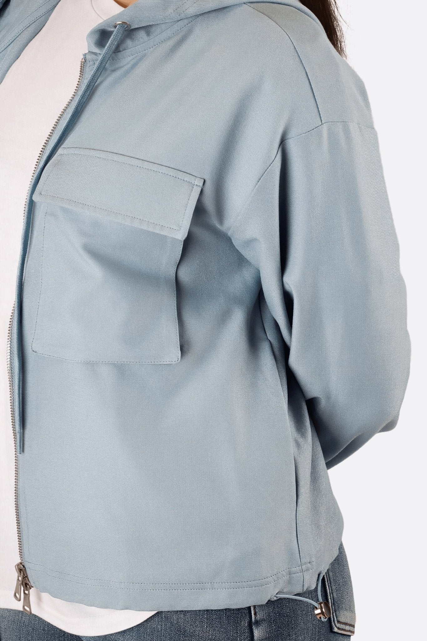 
Perspective différente de la veste zippée à capuche bleue, soulignant son design trendy pour des occasions décontractées.



