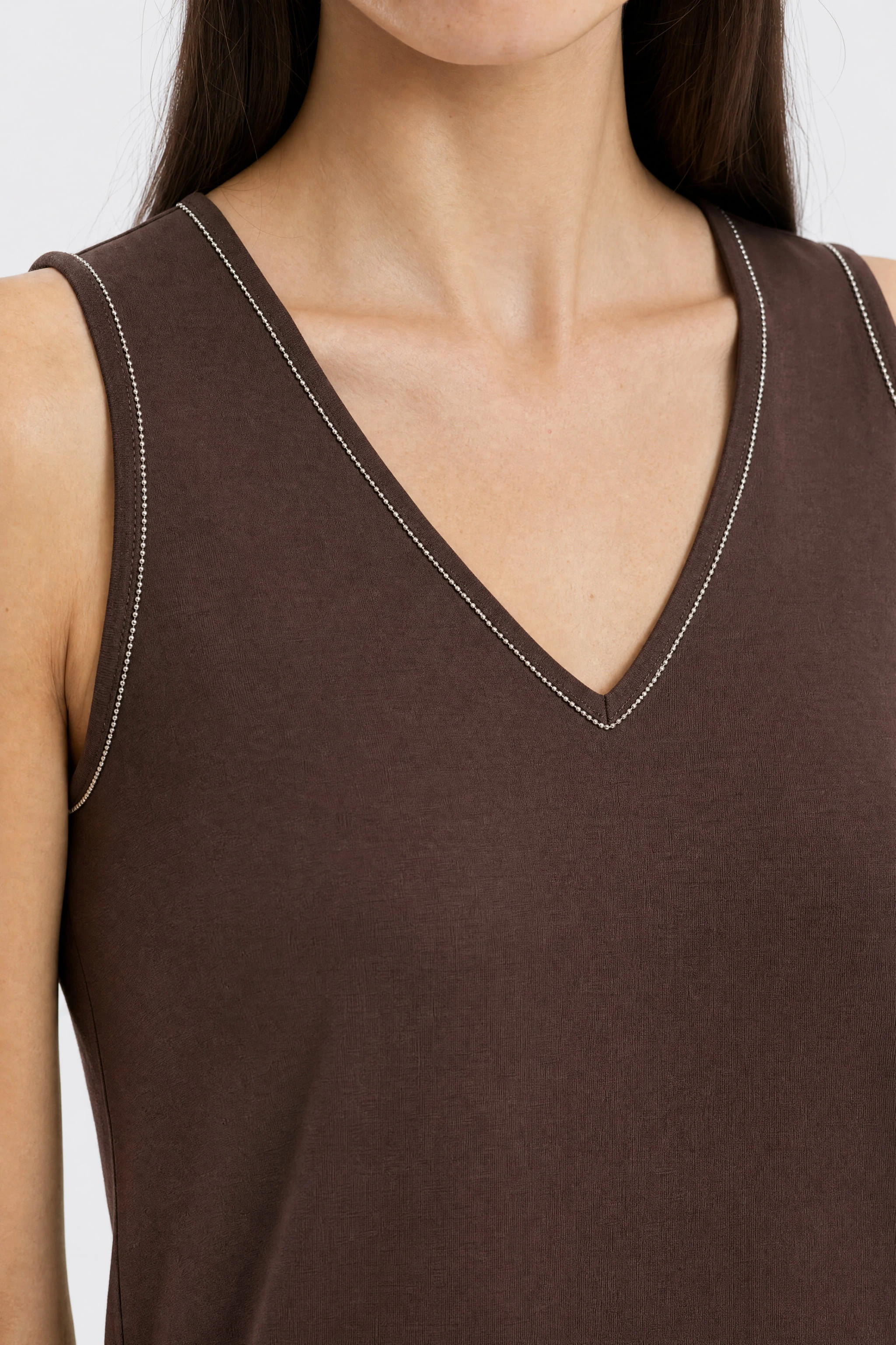 Detail of the silver bead chain sewn at the tip of the V neckline