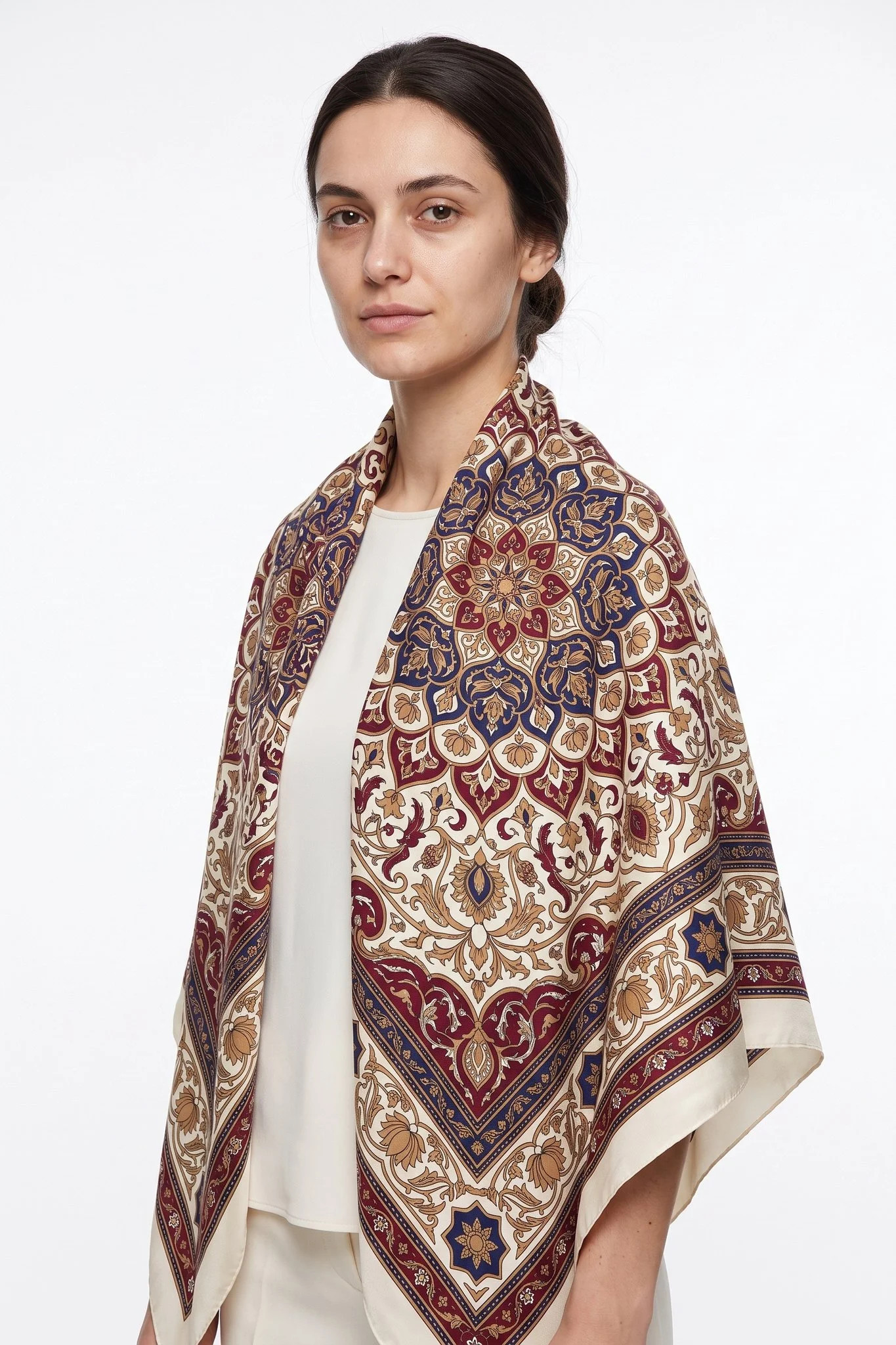 Large 110 silk scarf Tapis d'Orient worn as a stole over a woman's shoulders, studio view