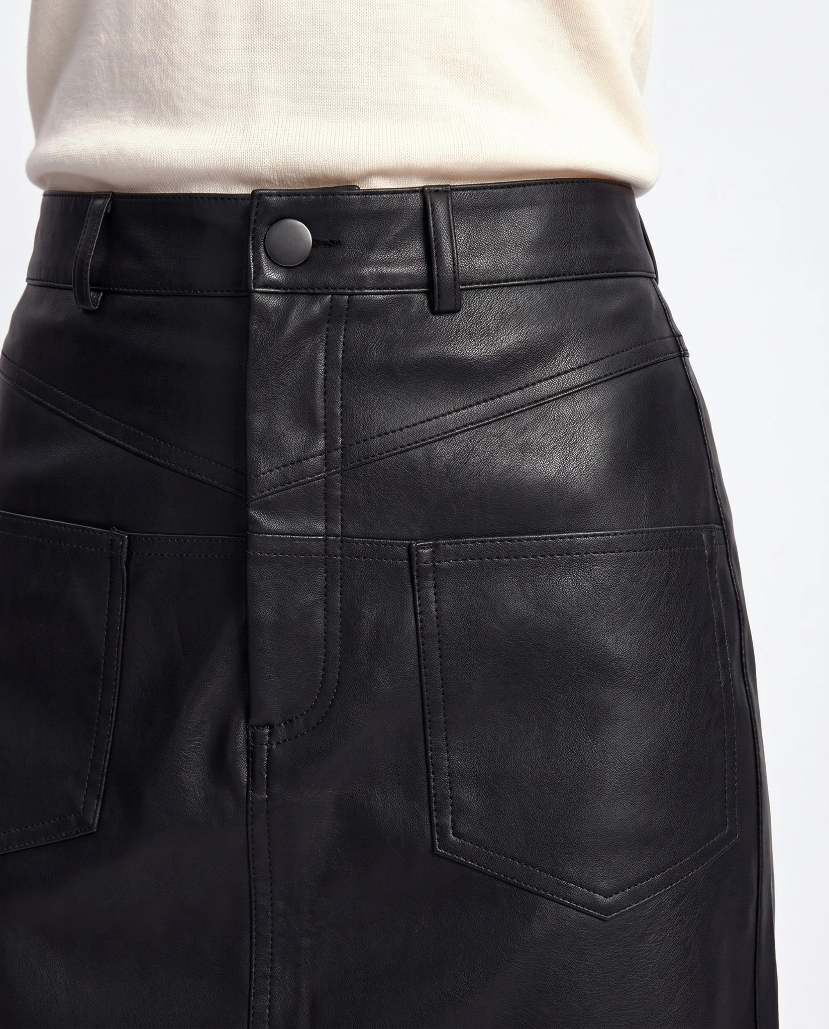 Détail de la ceinture noire : bouton pression gunmetal, passants vides et empiècement en pointe