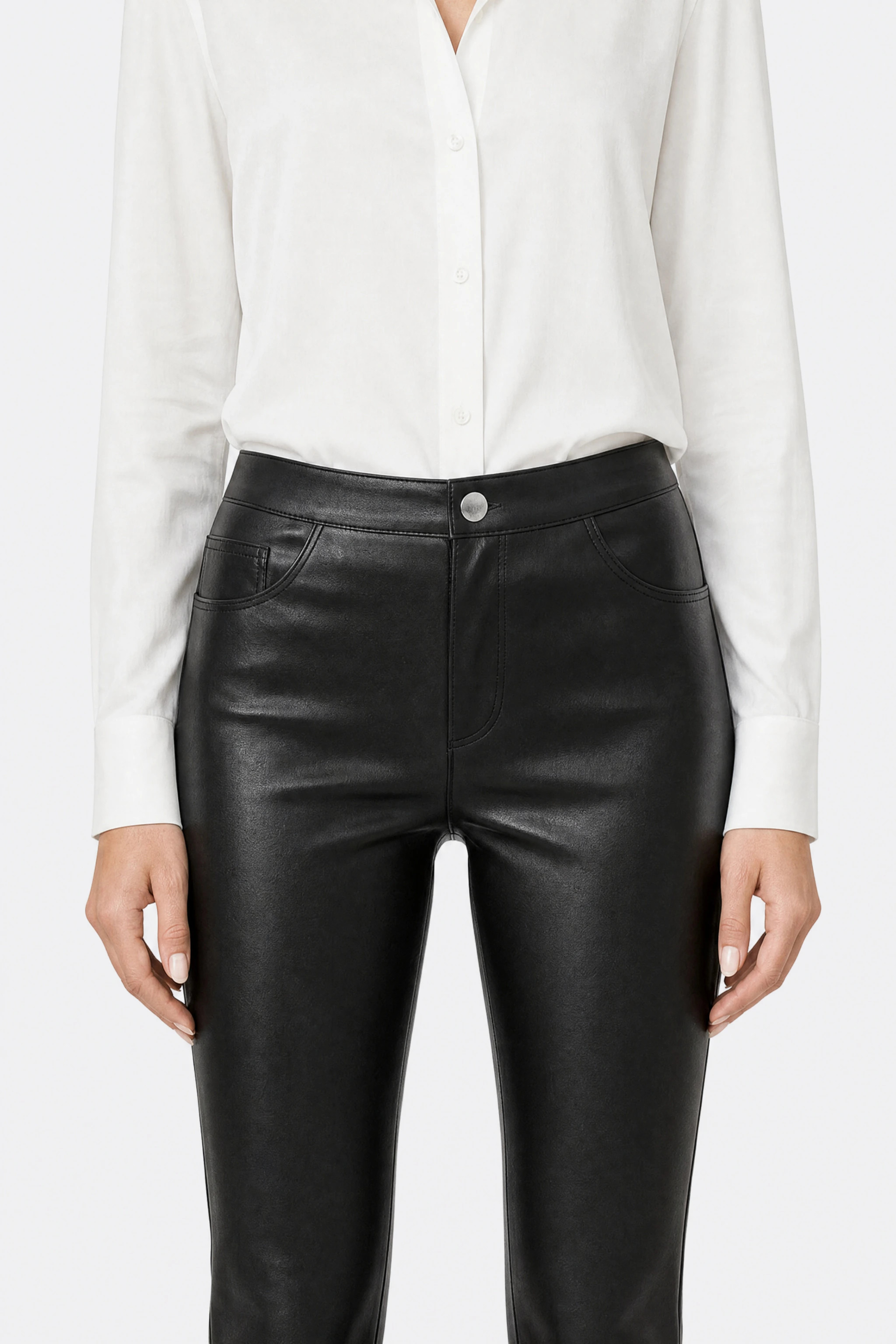 Black faux leather trousers, detail of the high waist, silver button, zip fly and front pockets