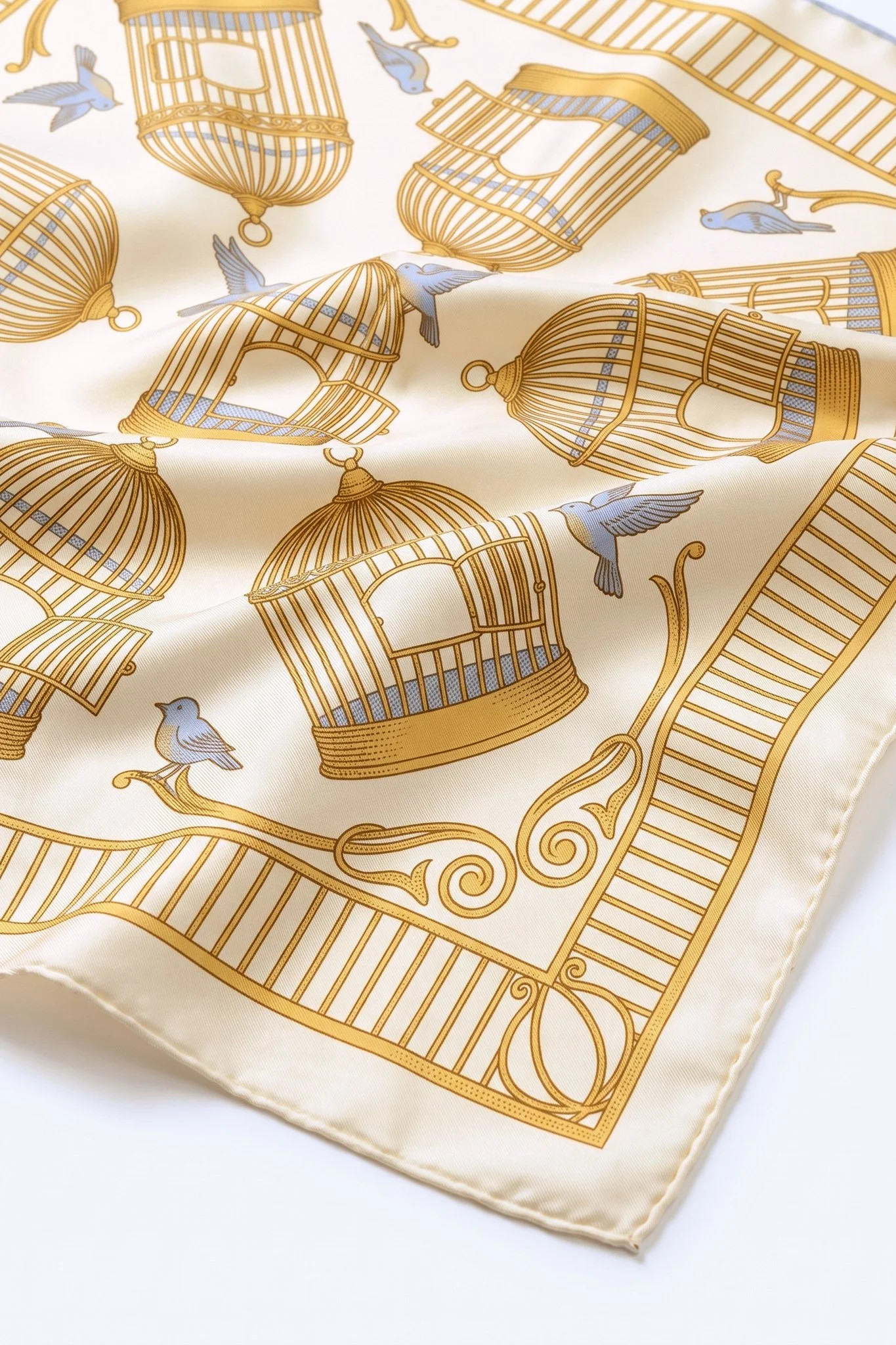 Close-up on the folds of the silk scarf Cages dorées, silk twill and hand-rolled hem
