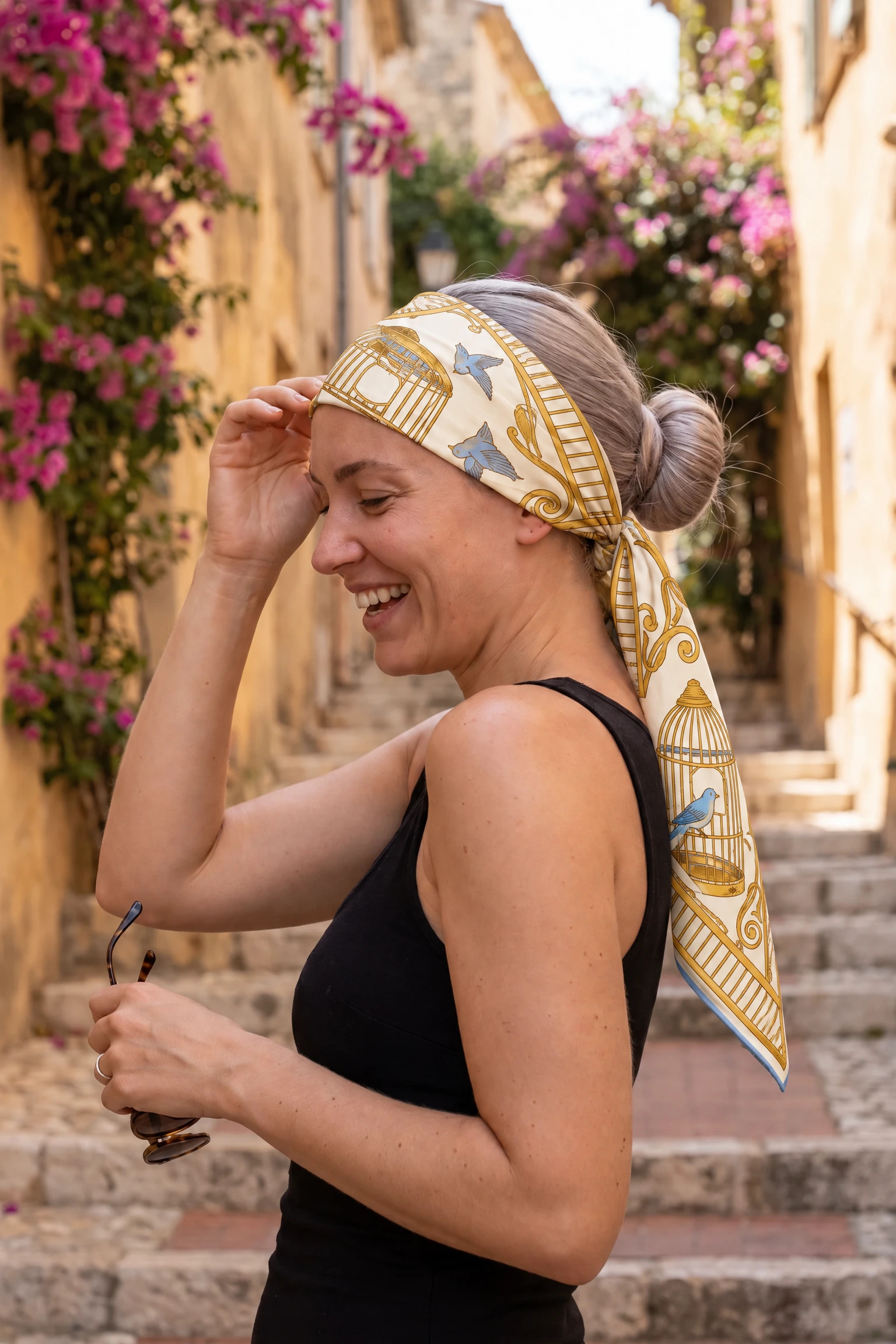 Woman wearing the silk scarf Cages dorées as a bandana in her hair on a Paris street