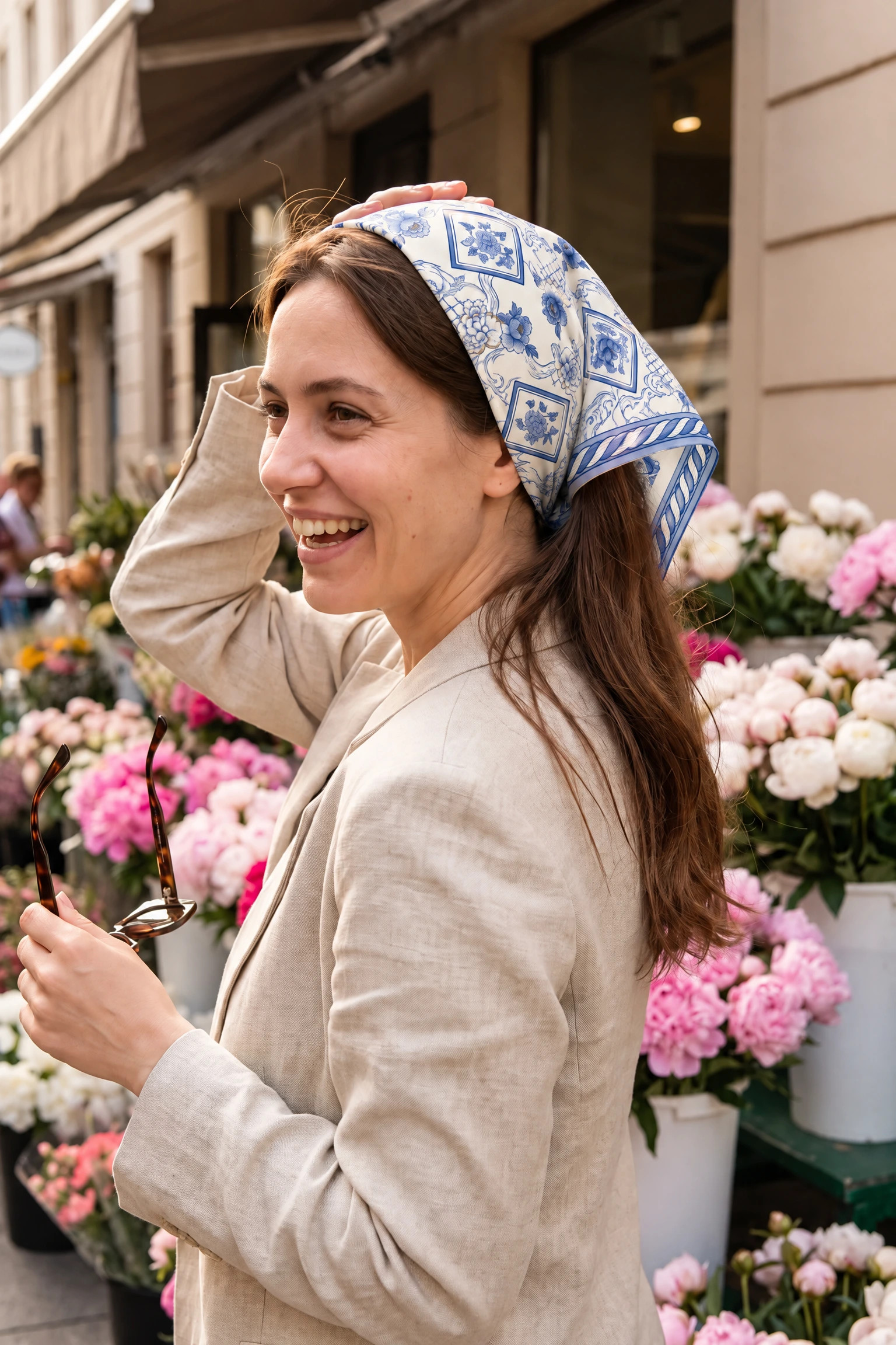 Woman wearing the silk scarf Camaïeu de porcelaine as a bandana in her hair on a Paris street