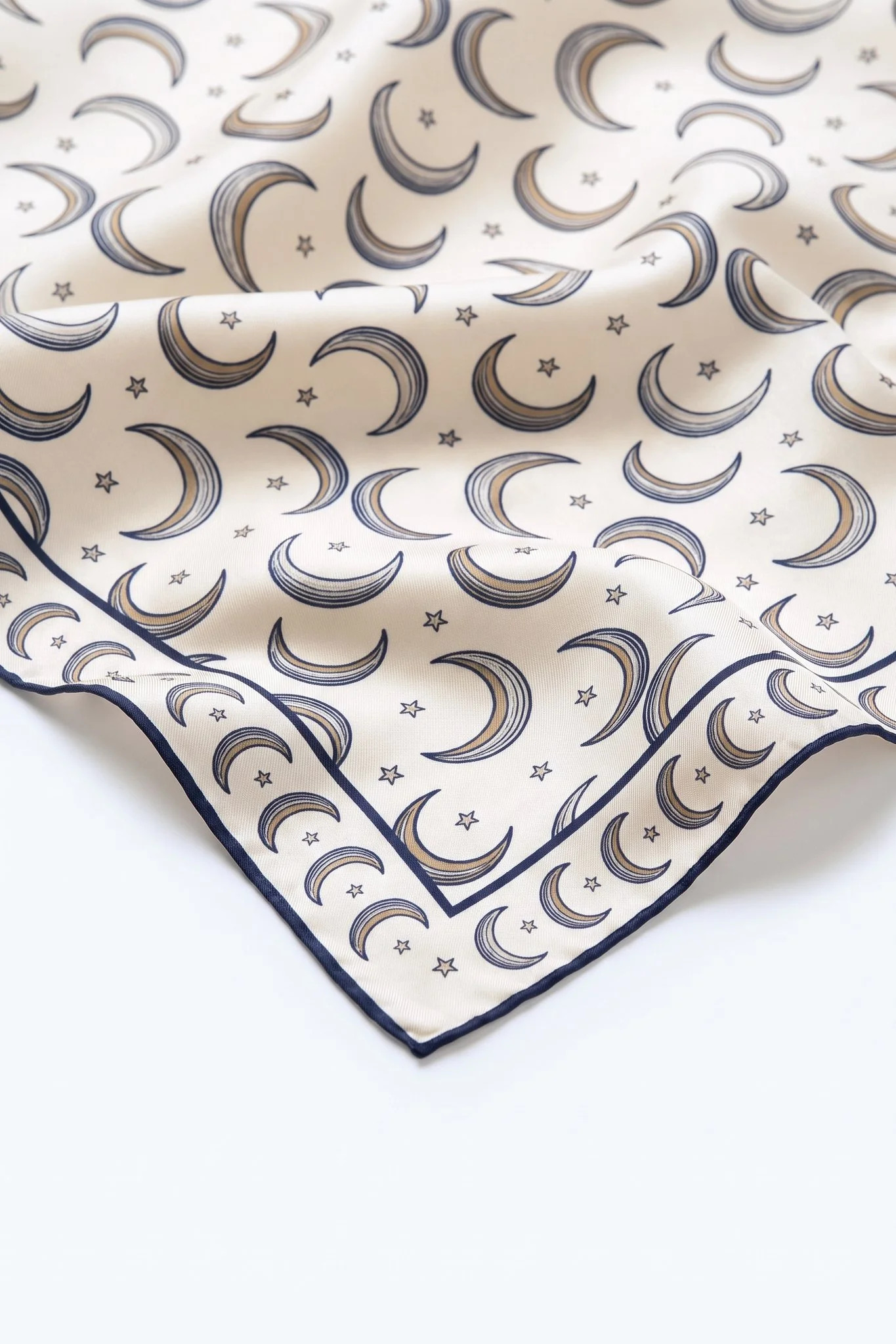 Close-up on the folds of the Croissants de lune silk scarf, silk twill and hand-rolled edge