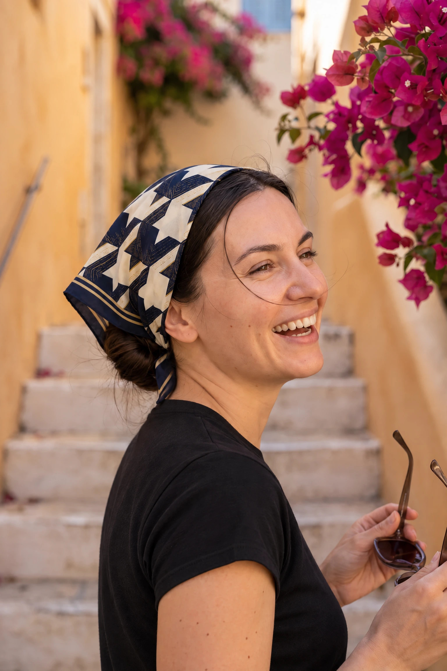 Woman wearing the Parisian houndstooth silk square as a bandana in her hair on a Paris street