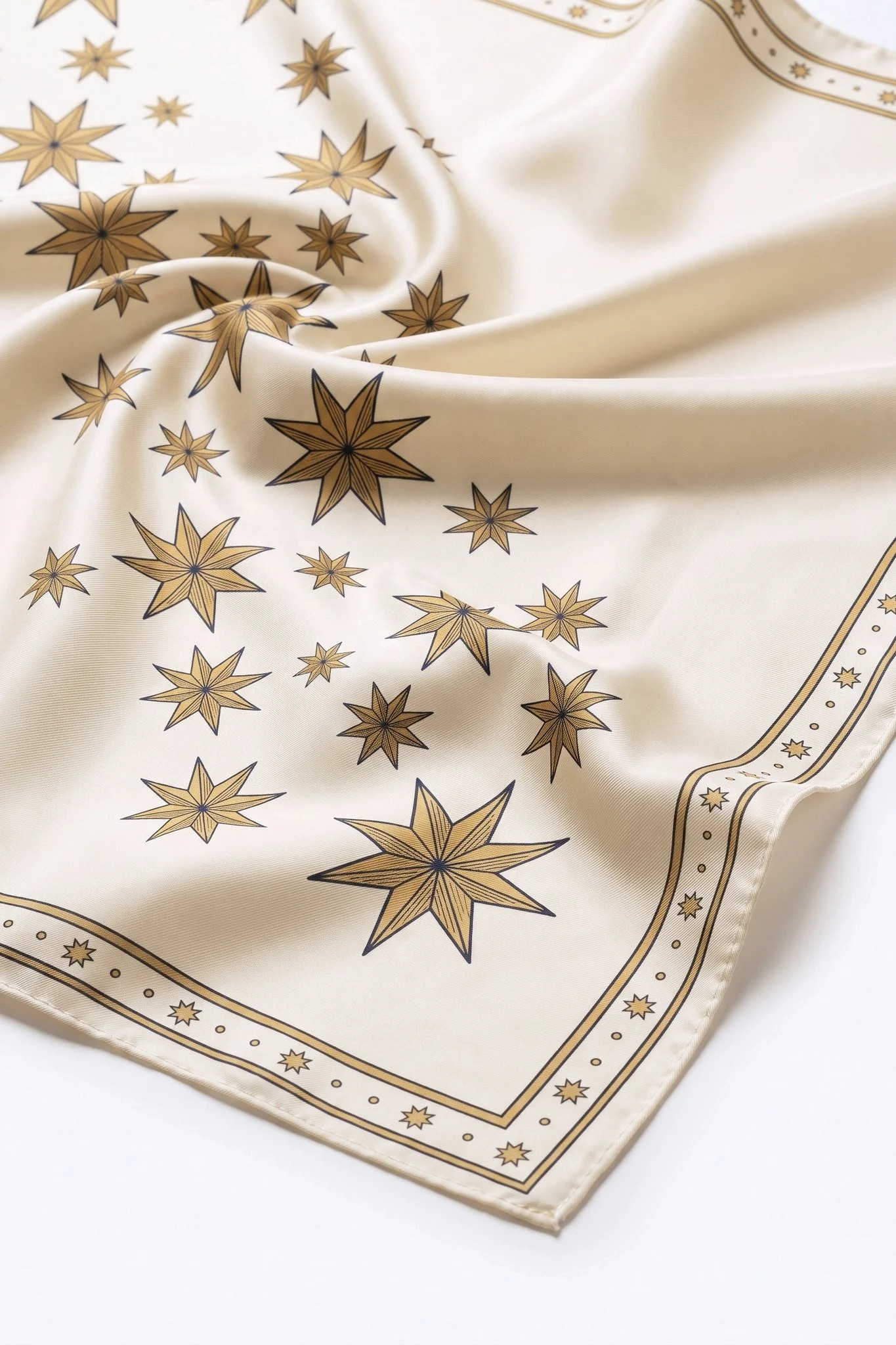 Close-up on the folds of the Pluie d'étoiles silk scarf, silk twill and hand-rolled edge