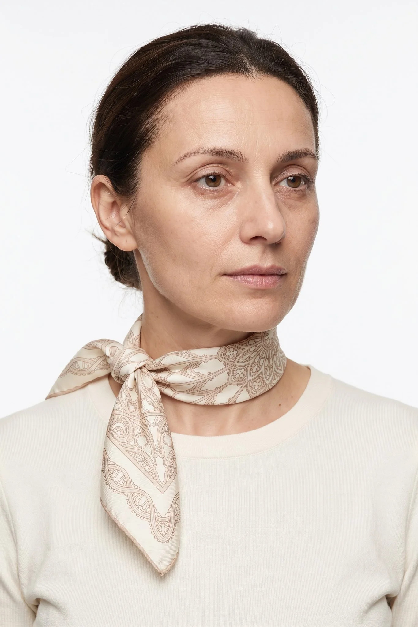 Small silk square 50 Rosace de fil worn tied around the neck as a small scarf by a woman, studio view