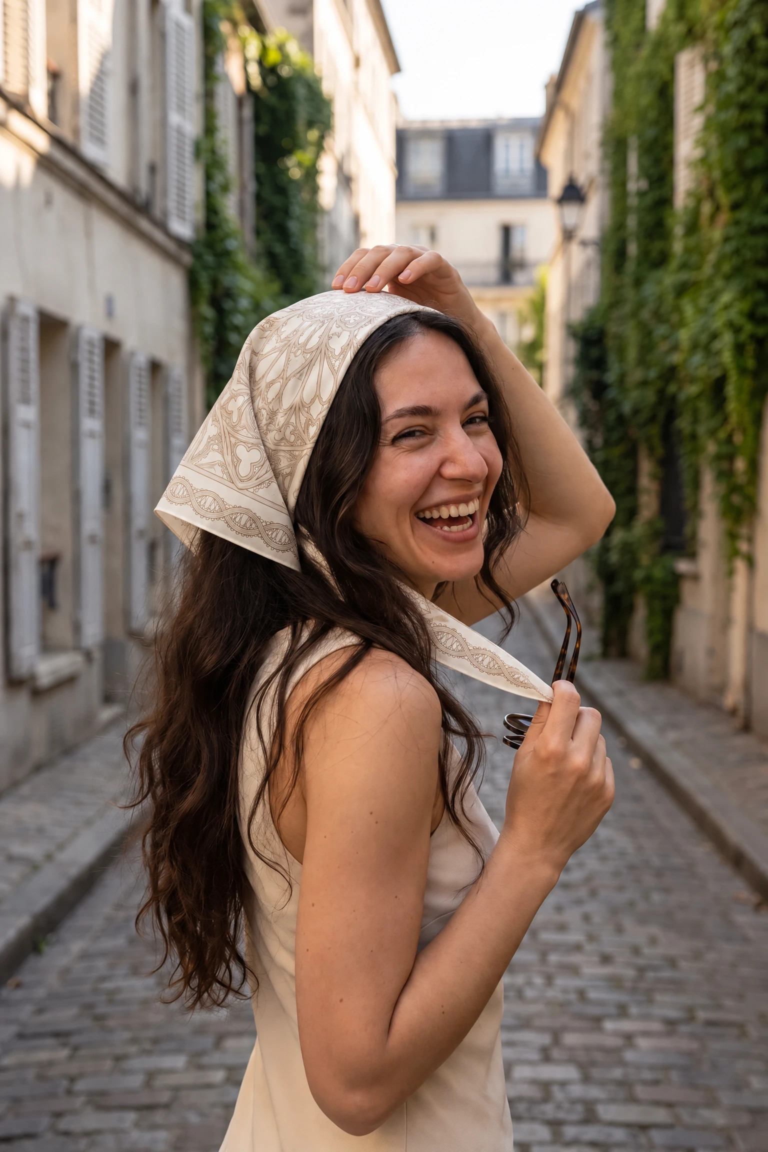 Woman wearing the silk square Rosace de fil as a bandana in her hair on a Paris street