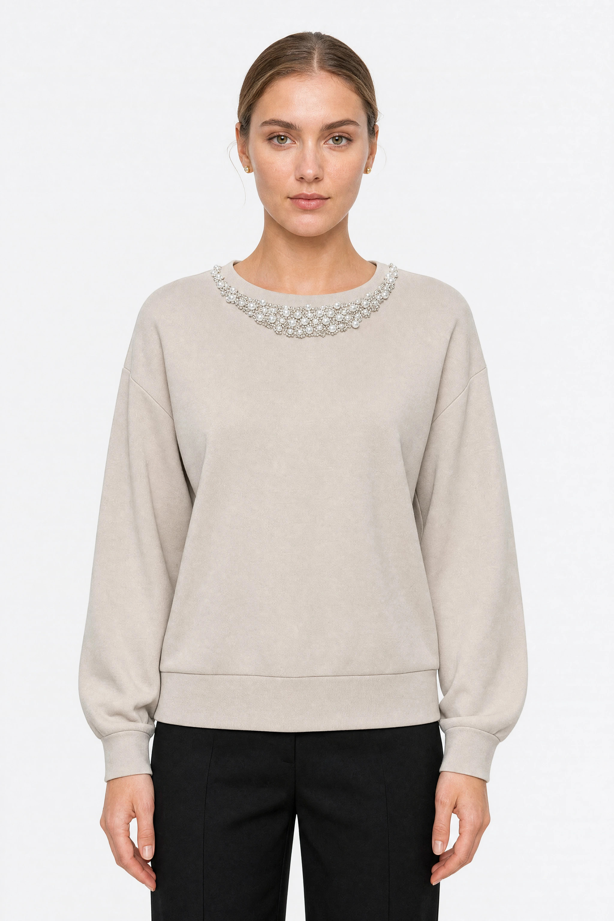 Buste du pull beige oversize porté, la bande de perles visible sur toute la largeur de l'encolure