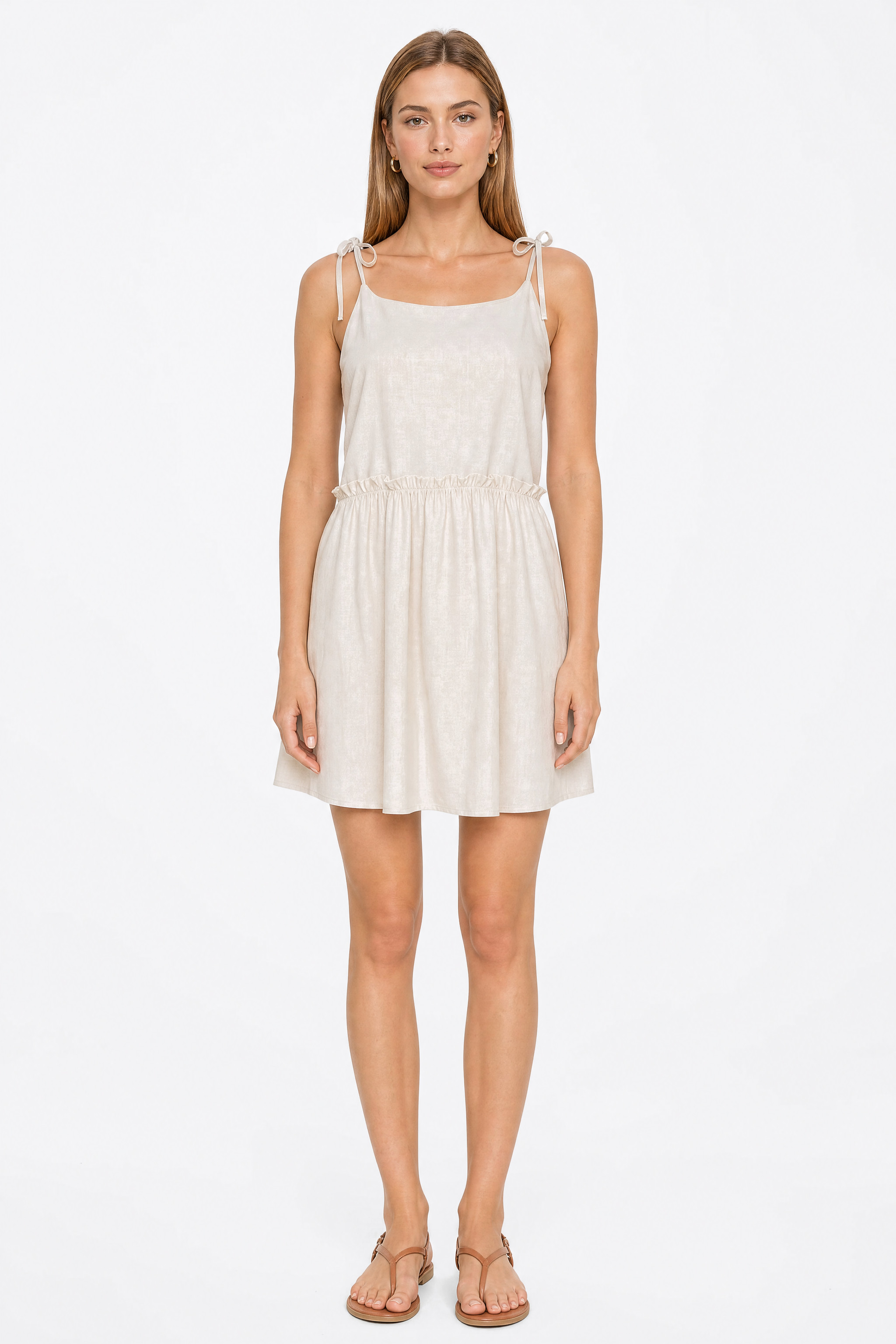 Short beige dress by Misciano worn from the front: straps tied on the shoulders, straight neckline and gathered waist