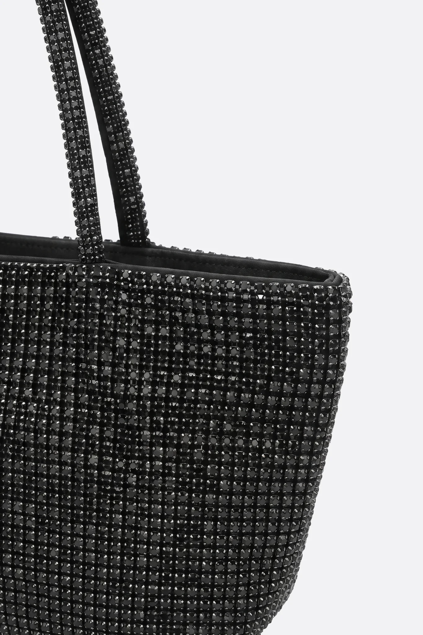 Dettaglio della maglia di strass e del manico della borsa tote nera