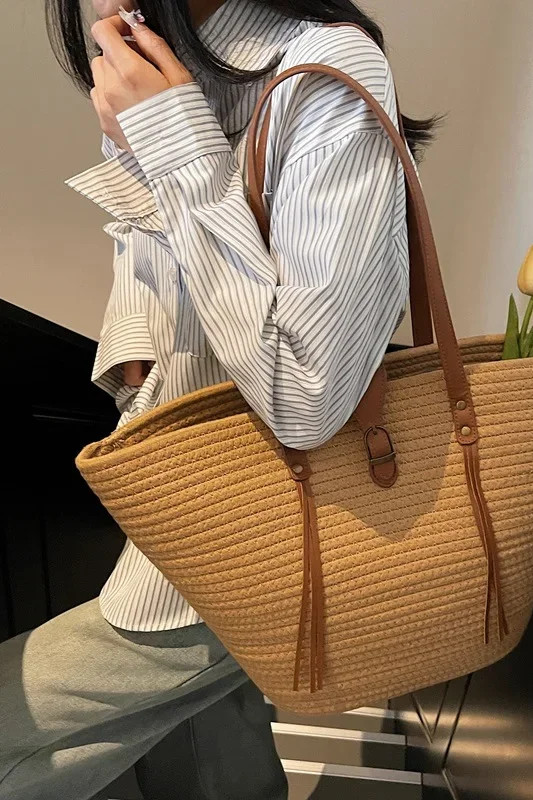 Borsa tote intrecciata effetto paglia marrone, portata sulla spalla